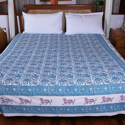 Handcrafted blue and white block print organic cotton bedspread with tiger motif, on double bed