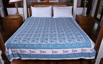 Handcrafted blue and white block print organic cotton bedspread with tiger motif, on double bed