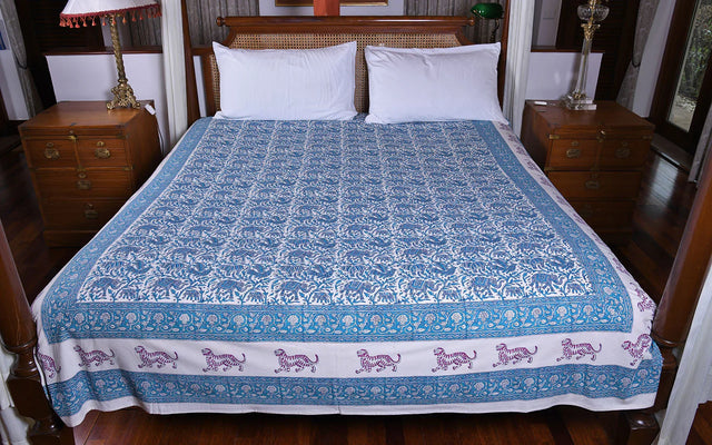 Handcrafted blue and white block print organic cotton bedspread with tiger motif, on double bed