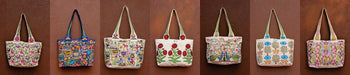 Handcrafted embroidered tote bags with colorful nature and wildlife designs, displayed on a wall