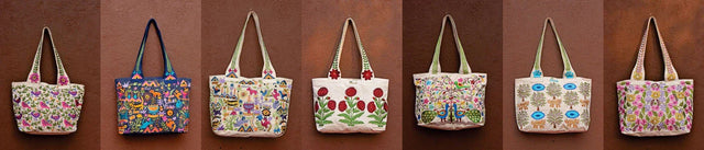 Handcrafted tote bags with colorful embroidered designs by Dhonk Craft, displayed against a brown wall.