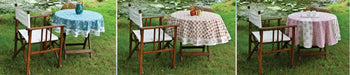 Handcrafted round cotton table covers with nature prints on outdoor wooden tables and chairs