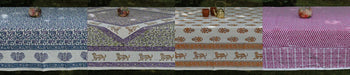 Handcrafted organic cotton tablecloths by Dhonk Craft, featuring vibrant block prints and nature-inspired patterns, displayed outdoors.