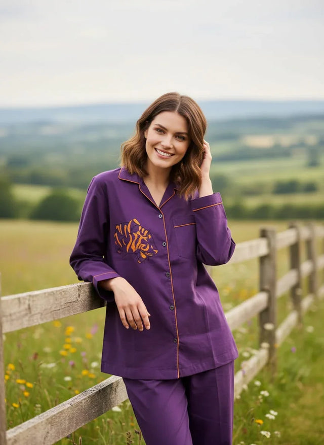 Woman wearing purple organic cotton shirt with tiger motif by Dhonk Craft, outdoors by a fence