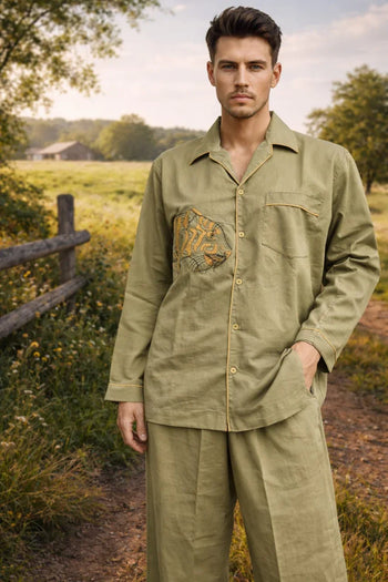 Man wearing handcrafted olive green organic cotton shirt and pants by Dhonk Craft outdoors