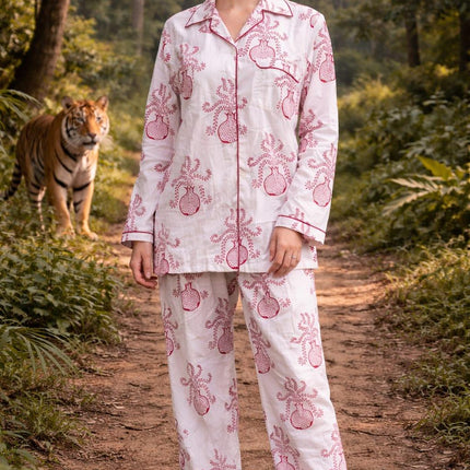 Woman in handcrafted organic cotton pajamas with pink floral print, standing on forest path with a tiger in the background, Dhonk Craft ethical clothing.