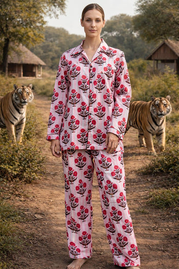 Woman in pink floral organic cotton pajamas by Dhonk Craft, standing outdoors with tigers nearby.