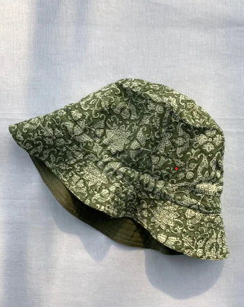 Handcrafted green organic cotton bucket hat with white floral pattern by Dhonk Craft