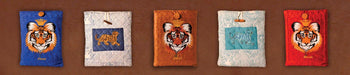 Handcrafted tiger and wildlife print cotton iPad covers by Dhonk Craft, styled on a brown background.
