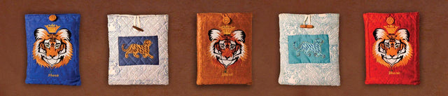 Handcrafted tiger and wildlife print cotton iPad covers by Dhonk Craft, styled on a brown background.