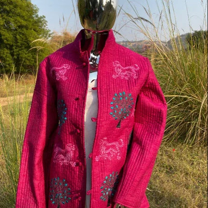 Handcrafted magenta cotton jacket with embroidered tree and animal motifs, outdoor setting