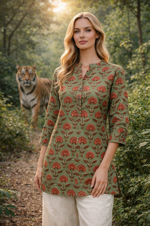 Model wearing Deepika brand olive green short cotton tunic with orange floral print and white linen pants.