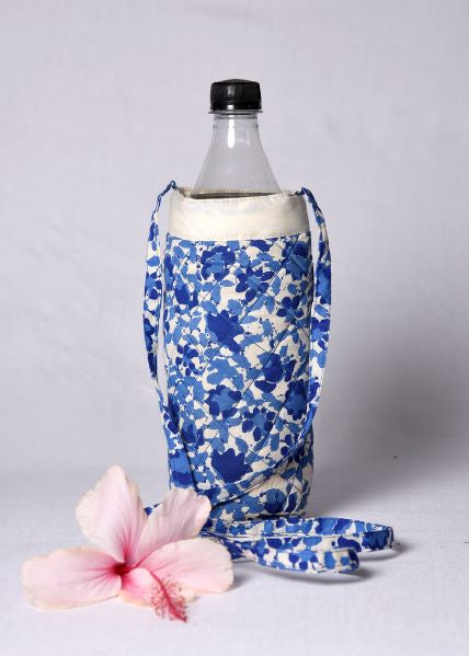 A floral quilted bottle cover in blue and white, displayed on a bottle with a sling bag.