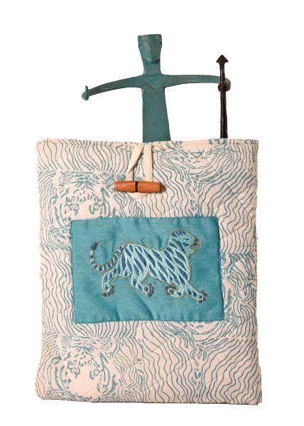 A quilted fabric tablet/iPad cover featuring floral embroidery and a character hand block print in blue on a beige background.