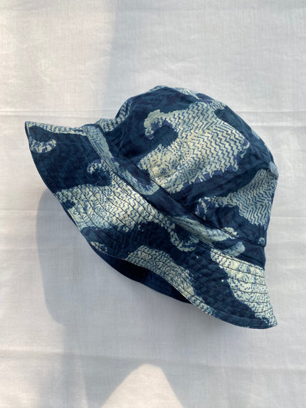 A hand block printed cotton hat with a floral pattern displayed on a flat surface.