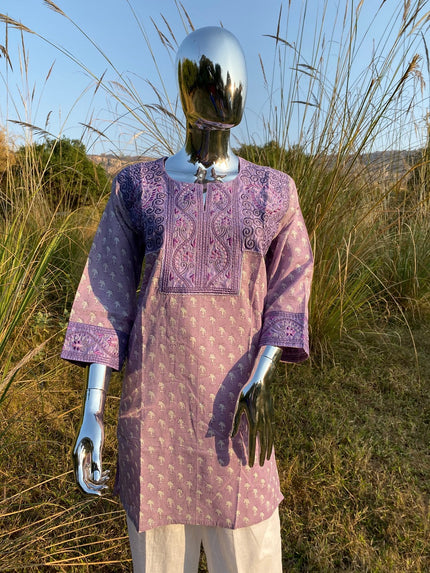 A mannequin displaying a purple and beige embroidered hand block print tunic with long sleeves.